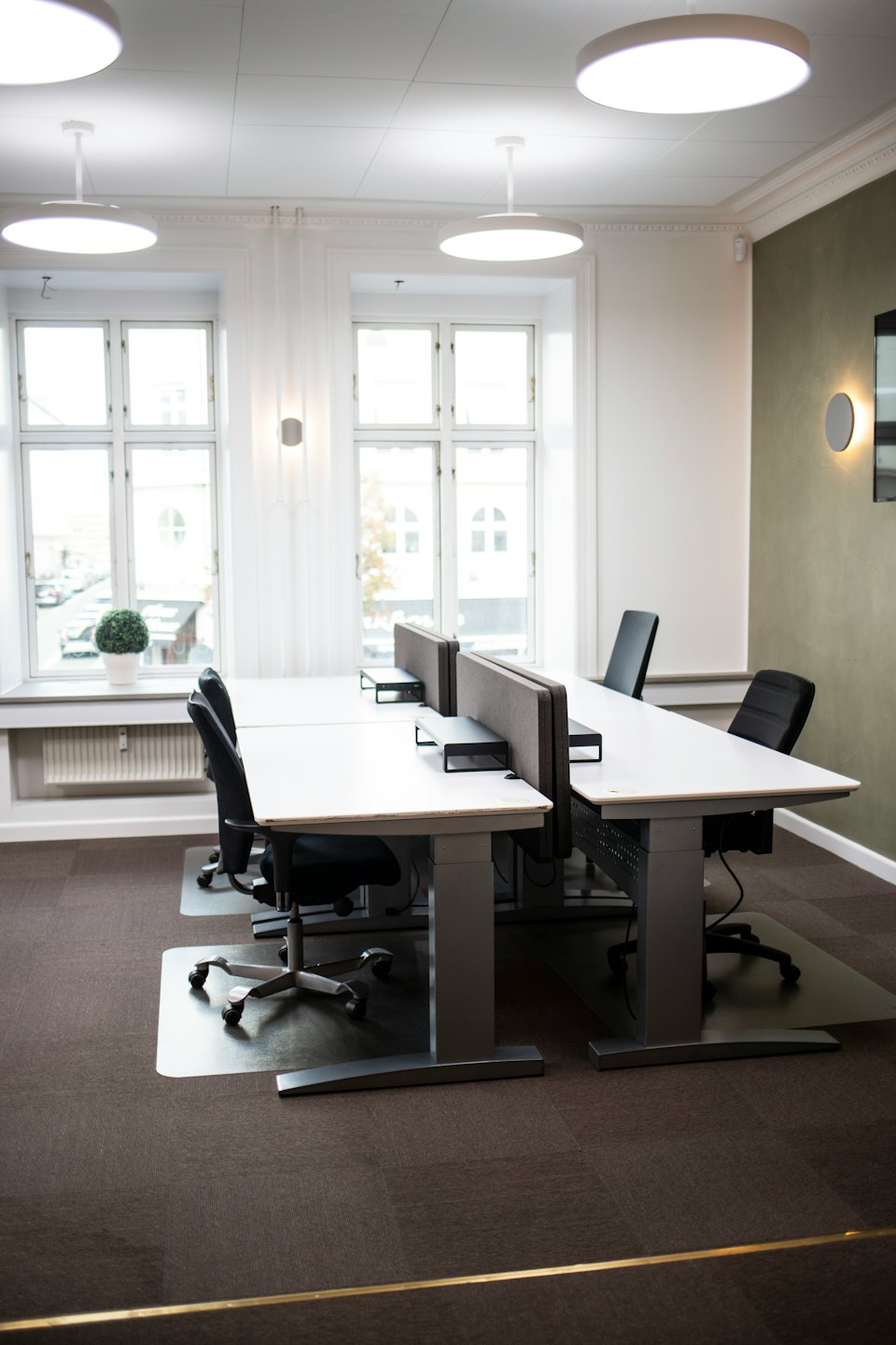 Empty workstations with chairs in a modern office space.