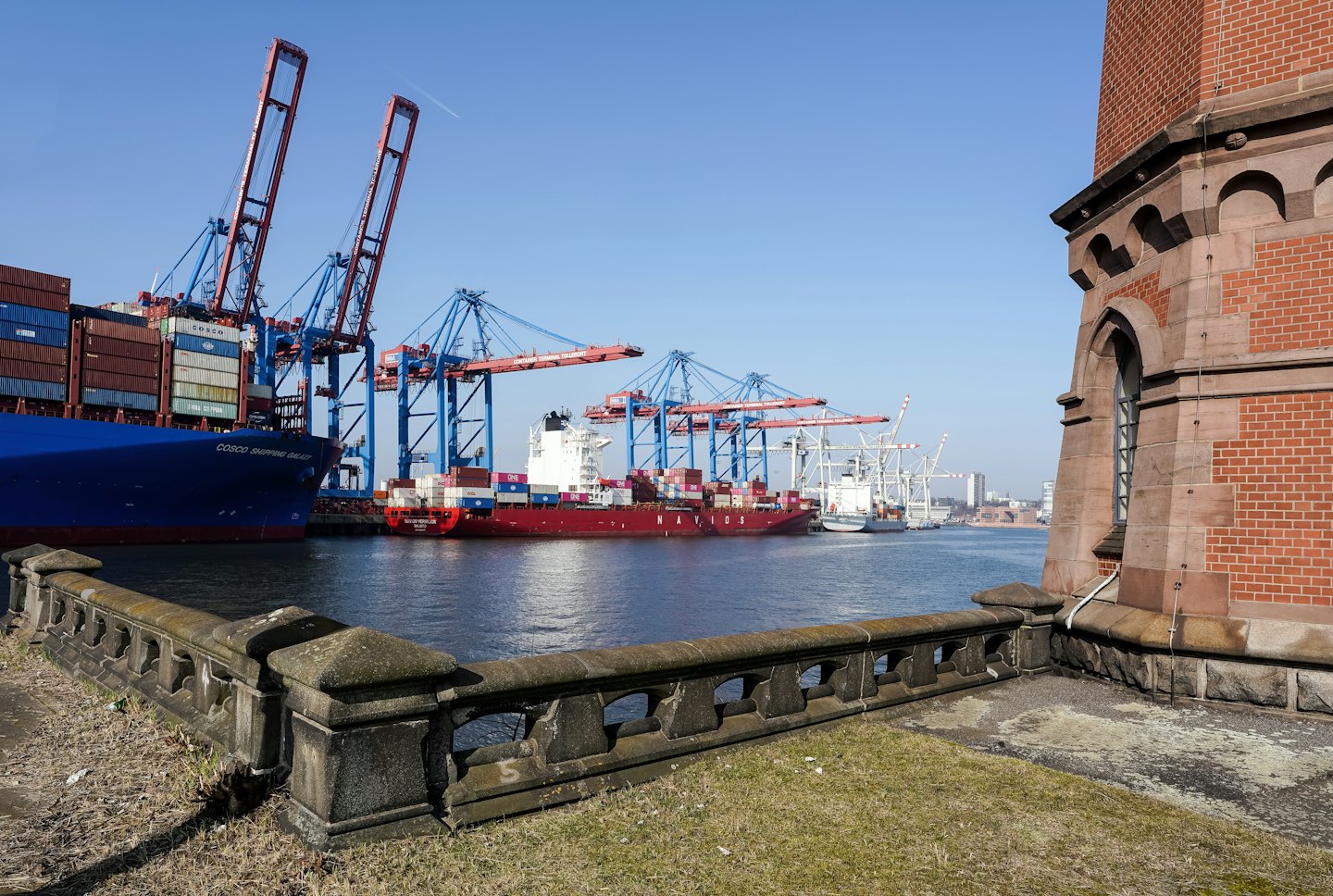 Container ships being loaded at a busy industrial port.